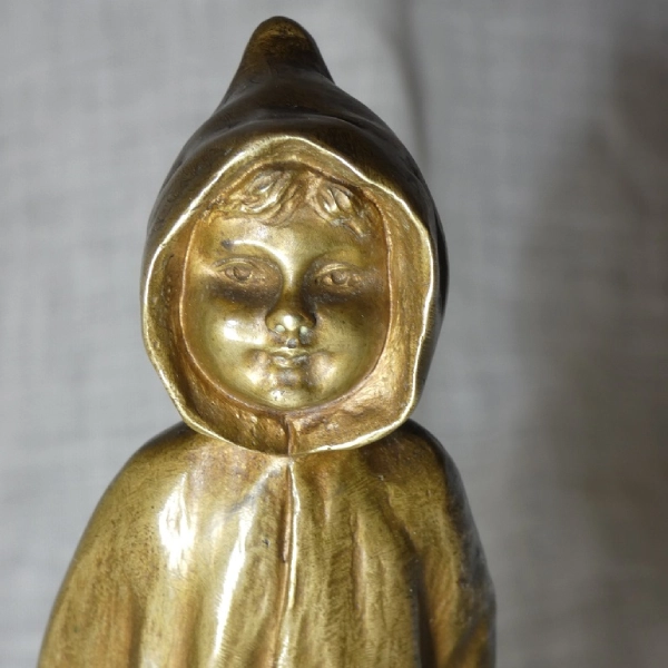 Statue dorée d'enfant avec capuche